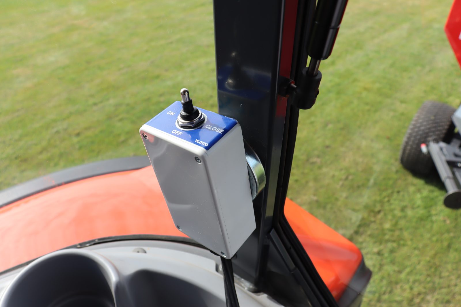 StarGreen TD1500T Trailed Turf Care Top Dresser from VALE Engineering showing in-cab control for conveyor belt engage and disengage.